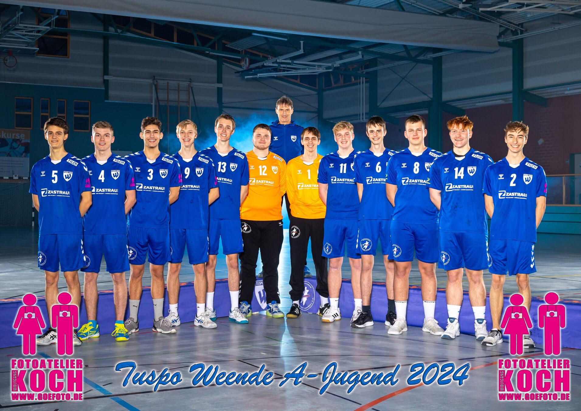 Mannschaftsbild der A-Jugend von Tuspo Weende 2024 in blauen Trikots, auf einer Sporthalle, Trainer in der Mitte.