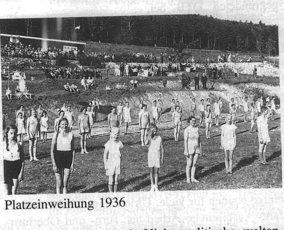 Gruppenschüler in Sportkleidung bei der Platzweihe 1936 auf einem Rasenplatz, im Hintergrund Zuschauer.